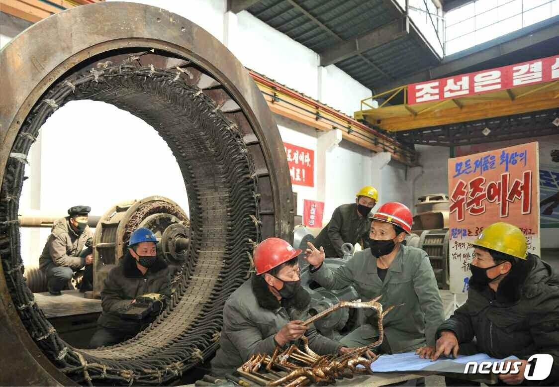 본문 이미지 - (평양 노동신문=뉴스1) = 성천강전기공장. 안전모와 마스크를 착용한 노동자들 뒤로는 정면 돌파전을 추동하기 위한 차원에서 '모든 제품을 최상의 수준에서'라는 선전 문구가 적혀있다. [국내에서만 사용가능. 재배포 금지. DB 금지. For Use Only in the Republic of Korea. Redistribution Prohibited] rodongphoto@news1.kr