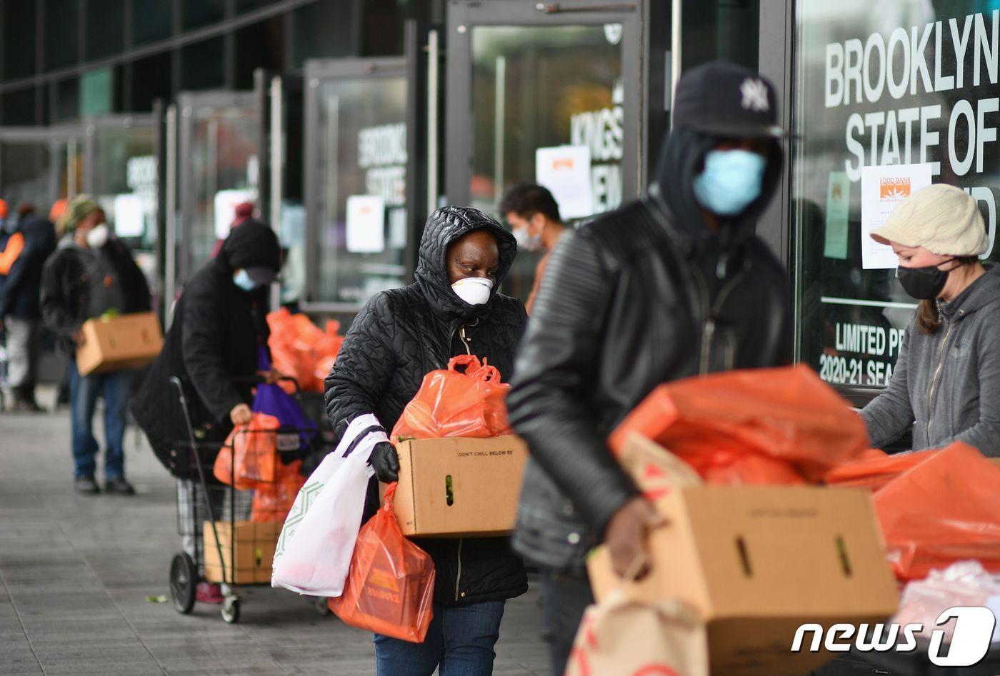 24일 미국 뉴욕 브루클린의 한 푸드뱅크에서 주민들이 식료품을 공급받고 있다. ⓒ AFP=뉴스1
