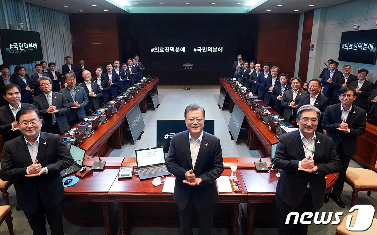 본문 이미지 - 문재인 대통령이 27일 오후 청와대에서 열린 수석·보좌관회의에 앞서 참모진들과 함께 '덕분에 챌린지'에 동참하고 있다. (청와대 제공) /뉴스1