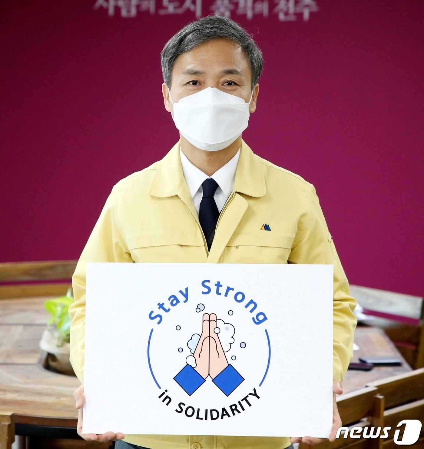 본문 이미지 - 김승수 전주시장이 28일 마스크를 쓴 채 'Stay Strong in SOLIDARITY'(굳은 연대로 굳건히 견디자)라는 메시지로 외교부 코로나19 극복 'Stay Strong'(스테이 스트롱) 릴레이 캠페인에 참여하고 있다.(전주시 제공)2020.4.28 /뉴스1 ⓒ News1