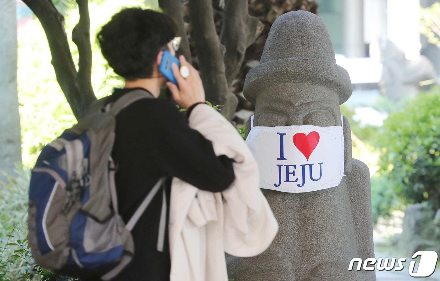 제주국제공항에서 관광객들이 마스크가 씌워진 돌하르방 앞ⓒ News1 