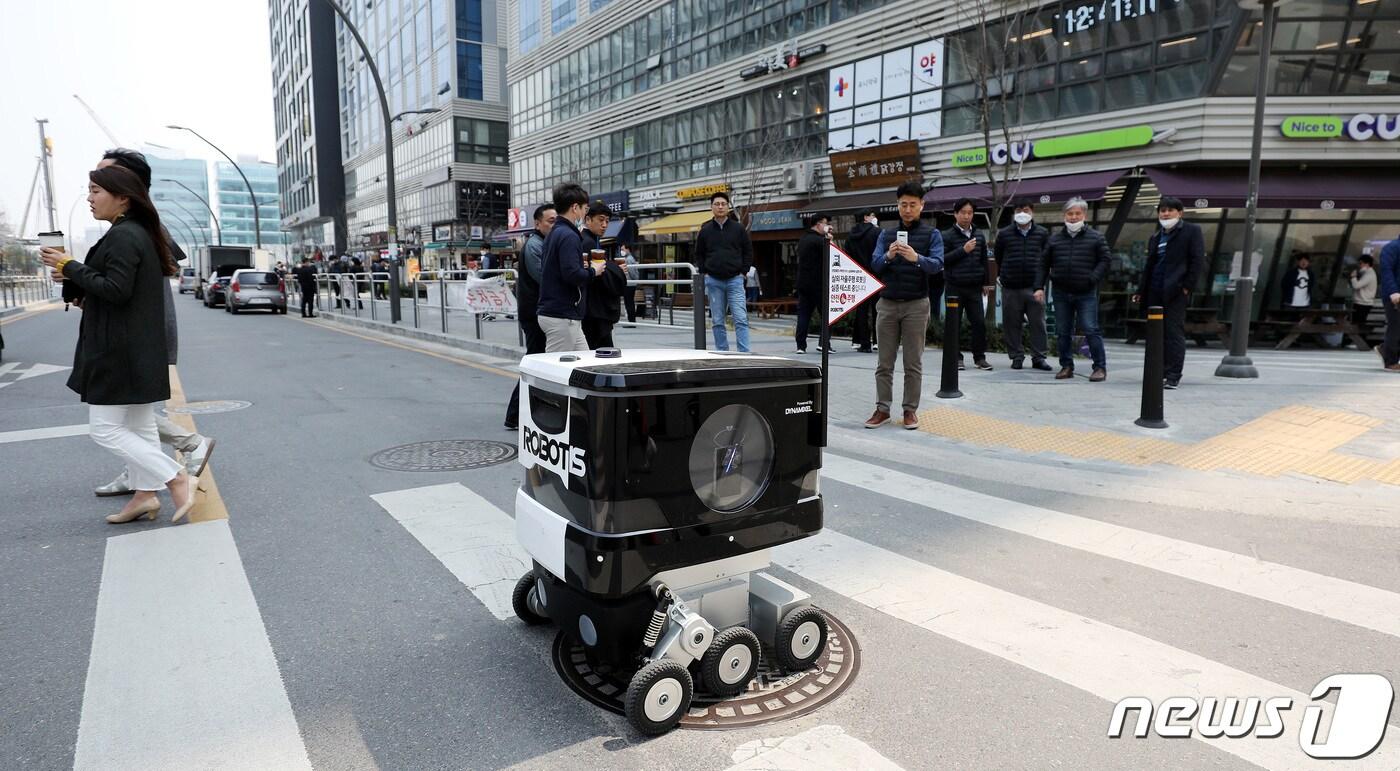 본문 이미지 - 한 로봇이 2020년 12월 실외 자율주행 로봇에 대한 규제 샌드박스 실증 특례를 통과해 점심식사를 배달하고 있다. (사진은 기사 내용과 무관함) / 뉴스1 ⓒ News1 