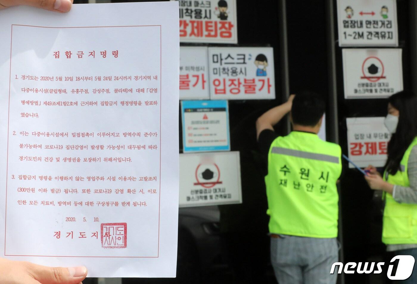 11일 오후 경기도 수원시내 한 클럽에서 수원시청 관계자들이 신종 코로나바이러스 감염증(코로나19) 확산 방지를 위한 집합금지명령서를 부착하고 있다. 2020.5.11/뉴스1 ⓒ News1 조태형 기자