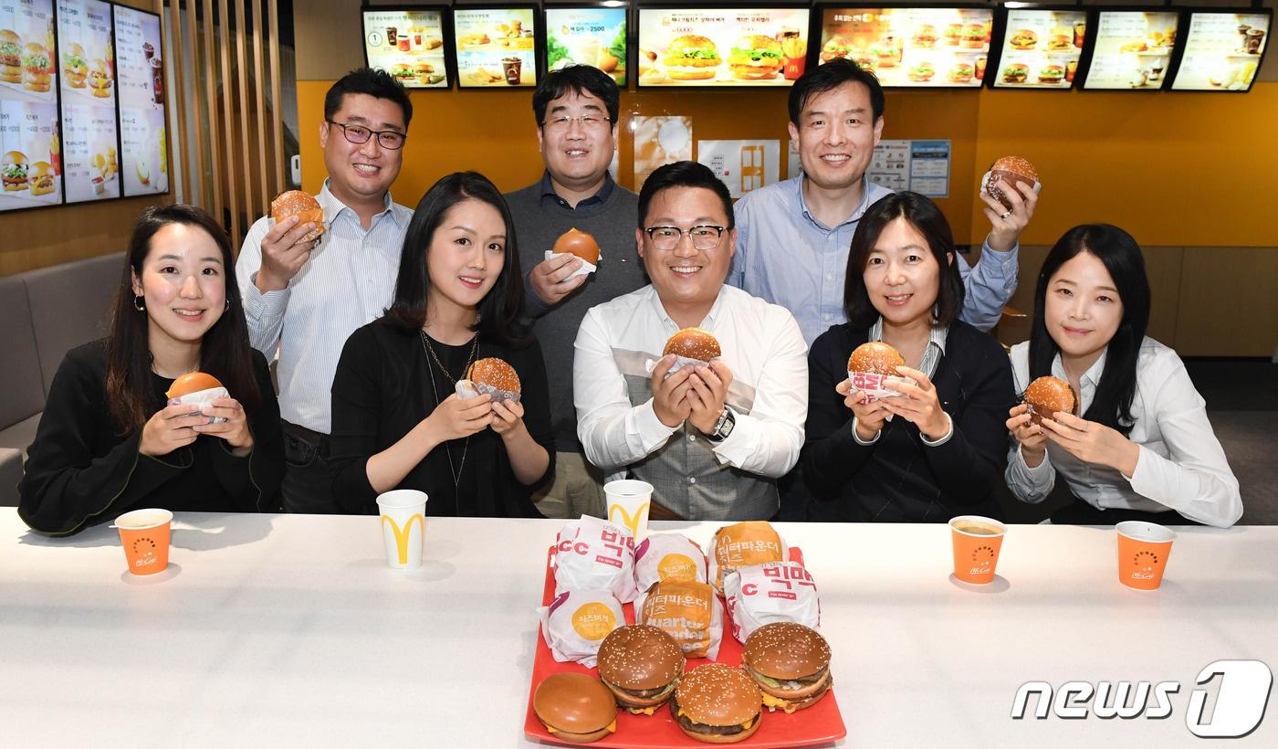 본문 이미지 - 한국맥도날드 '베스트 버거 태스크포스'(TF) 팀원 8명이 직접 개발한 '베스트 버거'를 선보이고 있다.  (첫째 줄 왼쪽부터) 최형원 팀원, 김정희 팀장, 심남규 이사, 최나영 팀원, 전남희 팀장. (둘째 줄 왼쪽부터) 백창호 팀장, 도정환 팀원, 이인규 팀원.ⓒ 뉴스1