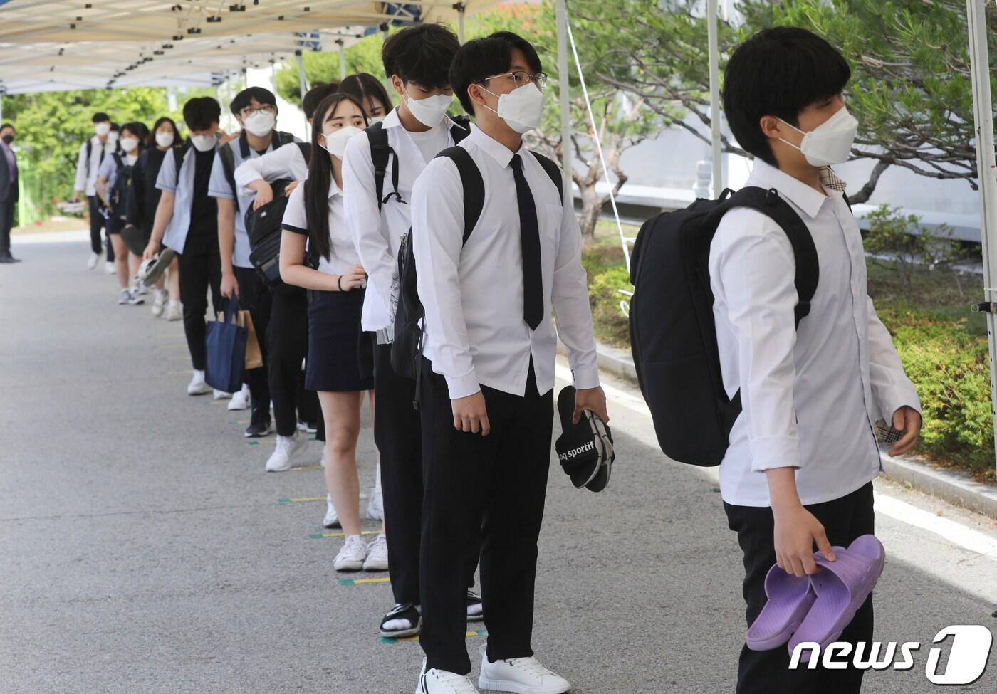 본문 이미지 - 고등학교 3학년 등교 개학이 시작된 20일 오전 충북 청주시 상당구 금천고등학교에서 학생들이 체온 검사를 위해 거리를 두며 줄 서있다. 2020.5.20/뉴스1 ⓒ News1 김용빈 기자