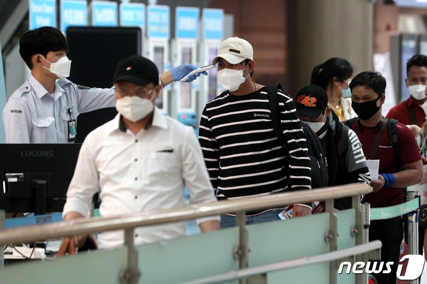 본문 이미지 - 27일 오후 인천국제공항 출국장에서 마스크를 쓴 승객들이 체온측정을 받고 있다. 정부는 신종 코로나 바이러스 감염증(코로나19) 확산을 막기 위해 이날부터 모든 국내·국제선 항공기 승객의 마스크 착용을 의무화 했다. 2020.5.27/뉴스1 ⓒ News1 황기선 기자