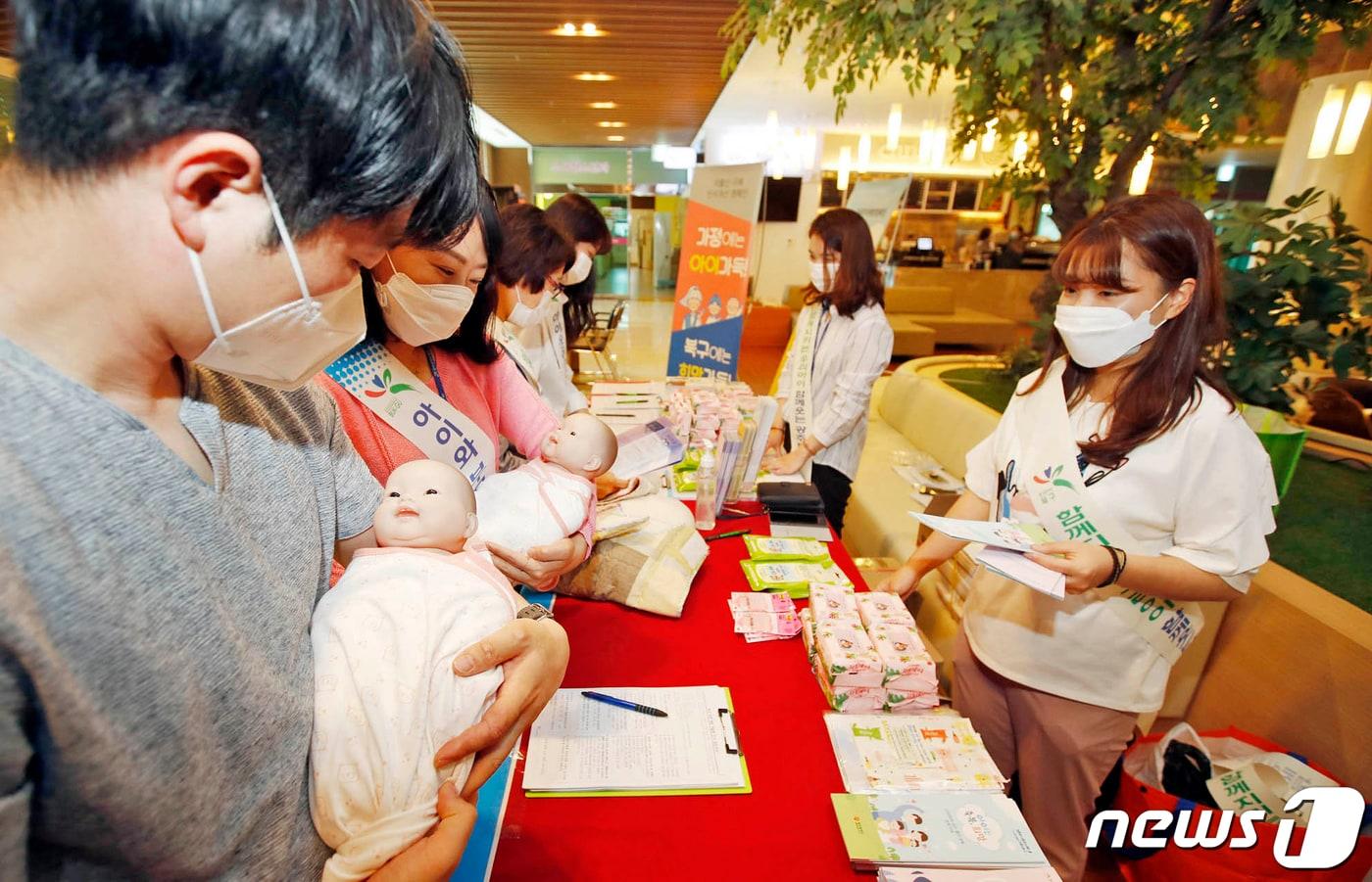 27일 광주 북구 빛고을여성병원에서 열린 저출산 대응 민관 릴레이 캠페인에서 북구청 저출산아동정책팀 직원들과 인구보건복지협회원들이 임산부와 예비아빠 등에게 신생아 속싸개 싸는 법 등 출산장려 홍보활동을 펼치고 있다. (광주북구 제공)2020.5.27/뉴스1 ⓒ News1 황희규 기자