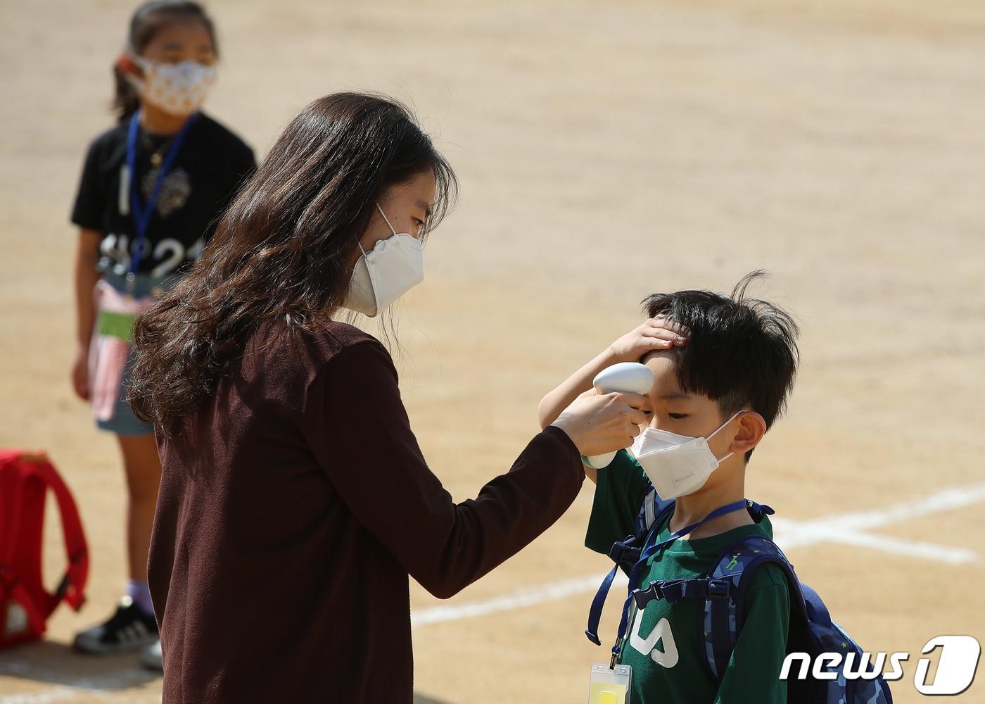 본문 이미지 - 27일 대구 한 초등학교 운동장에서 신종 코로나바이러스 감염증(코로나19) 확산 여파로 온라인 입학 후 87일만에 처음으로 등교한 1학년 신입생들이 발열 검사를 받고 있다. /뉴스1 ⓒ News1 공정식 기자