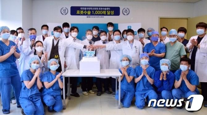 본문 이미지 - 6일 김하용 원장과 로봇수술센터 의료진 및 관계자들이 로봇수술 1000례 달성을 자축하고 있다.ⓒ 뉴스1