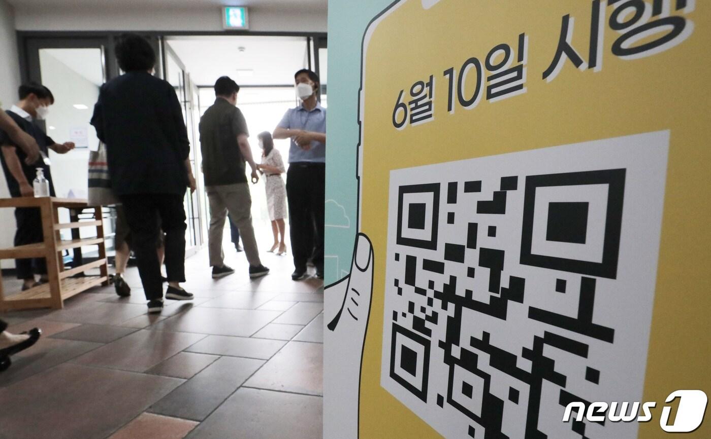 정부가 수도권 방역강화 조치를 무기한 연장한 가운데 지난 14일 오전 서울 송파구 신천동성당에서 교인들이 예배에 참석하기 위해 전자출입명부(QR코드)를 찍고 있다.  ⓒ News1 이성철 기자