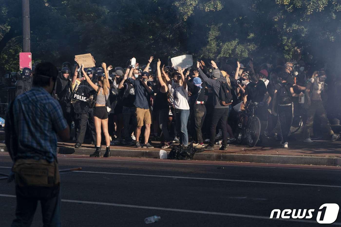 1일 미국 워싱턴DC에서 흑인 조지 플로이드의 사망에 항의하는 시위대가 피켓을 들고 소리치고 있다. ⓒ AFP=뉴스1