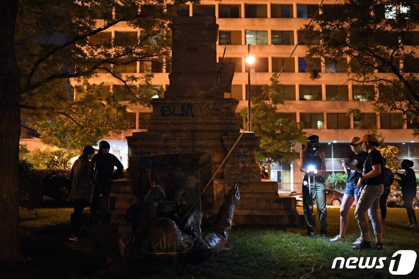 2020년 6월 19일 밤, 워싱턴 D.C.의 사법광장&#40;Judiciary Square&#41;에서 남부연합 장군 앨버트 파이크의 동상이 시위대에 의해 철거된 뒤, 사람들이 그 주변에 모여 있다.ⓒ AFP=뉴스1