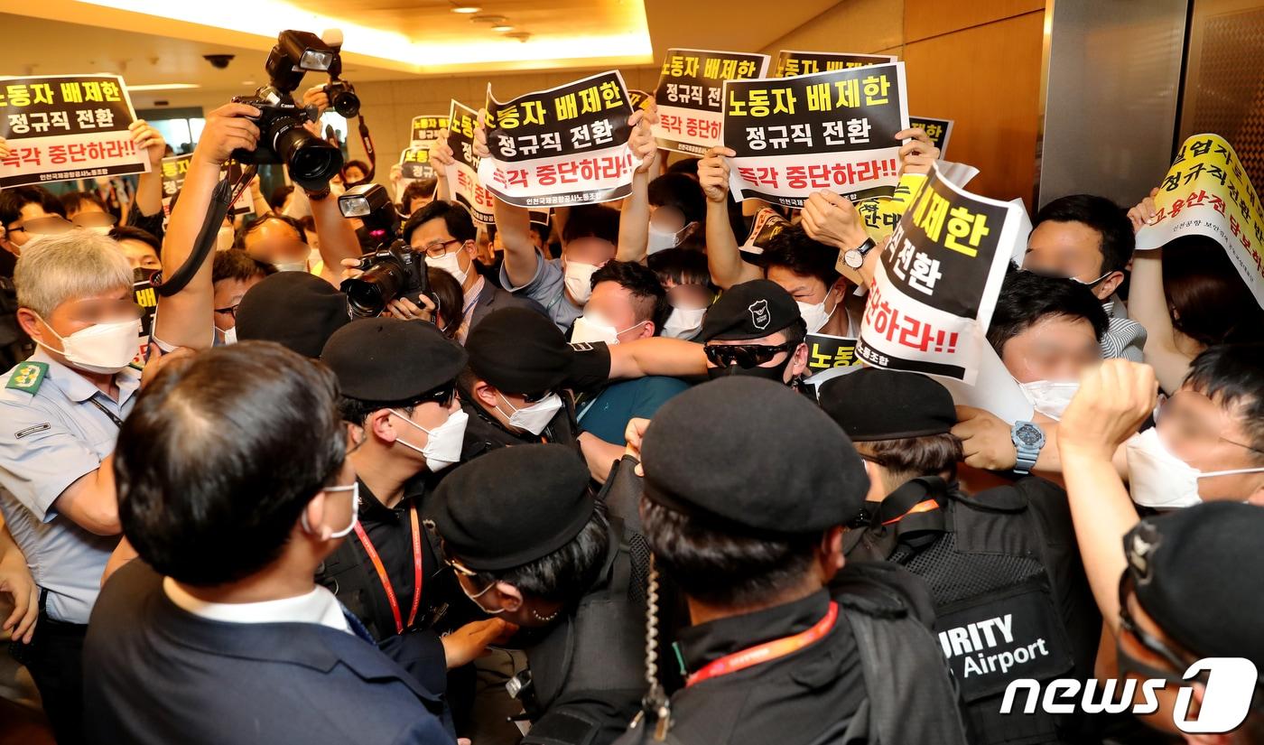 구본환 인천국제공항공사 사장이 지난 22일 오후 인천공항1터미널에서 열린 기자회견에서 정규직 전환에 대한 입장을 밝히고 퇴장하자 정규직 전환을 반대하는 노동자들이 항의를 하고 있다. 인천공항공사는 이날 인천공항 보안요원 1900여명을 정규직화 한다고 밝혔다.2020.6.22/뉴스1 ⓒ News1 정진욱 기자