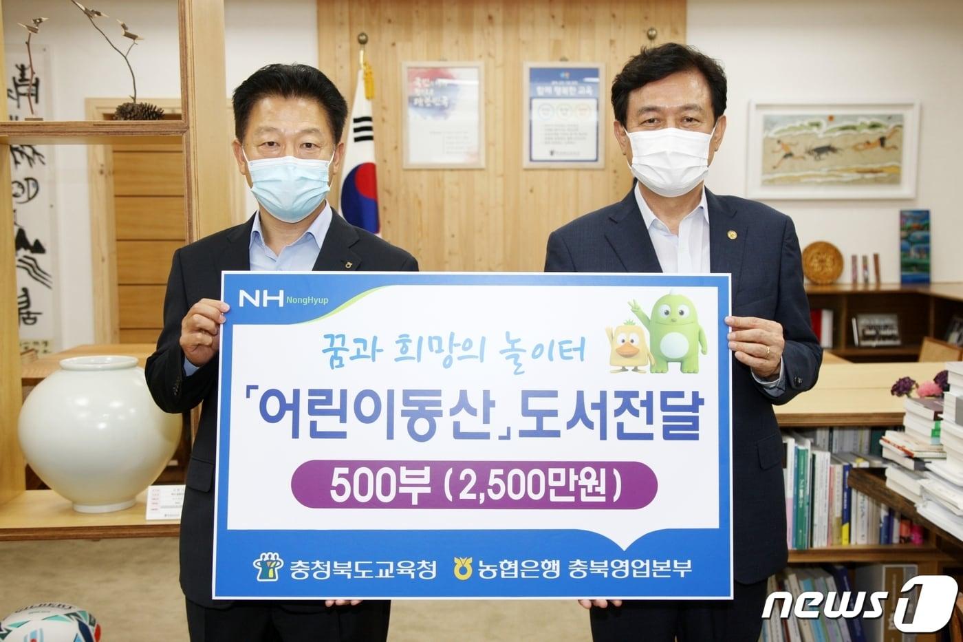본문 이미지 - 24일 오전 태용문 NH농협은행 충북영업본부장(왼쪽)이 충청북도교육청을 찾아 김병우 교육감에게 월간지 ‘어린이 동산’ 500권 연간구독 증서를 기증하고 있다./뉴스1
