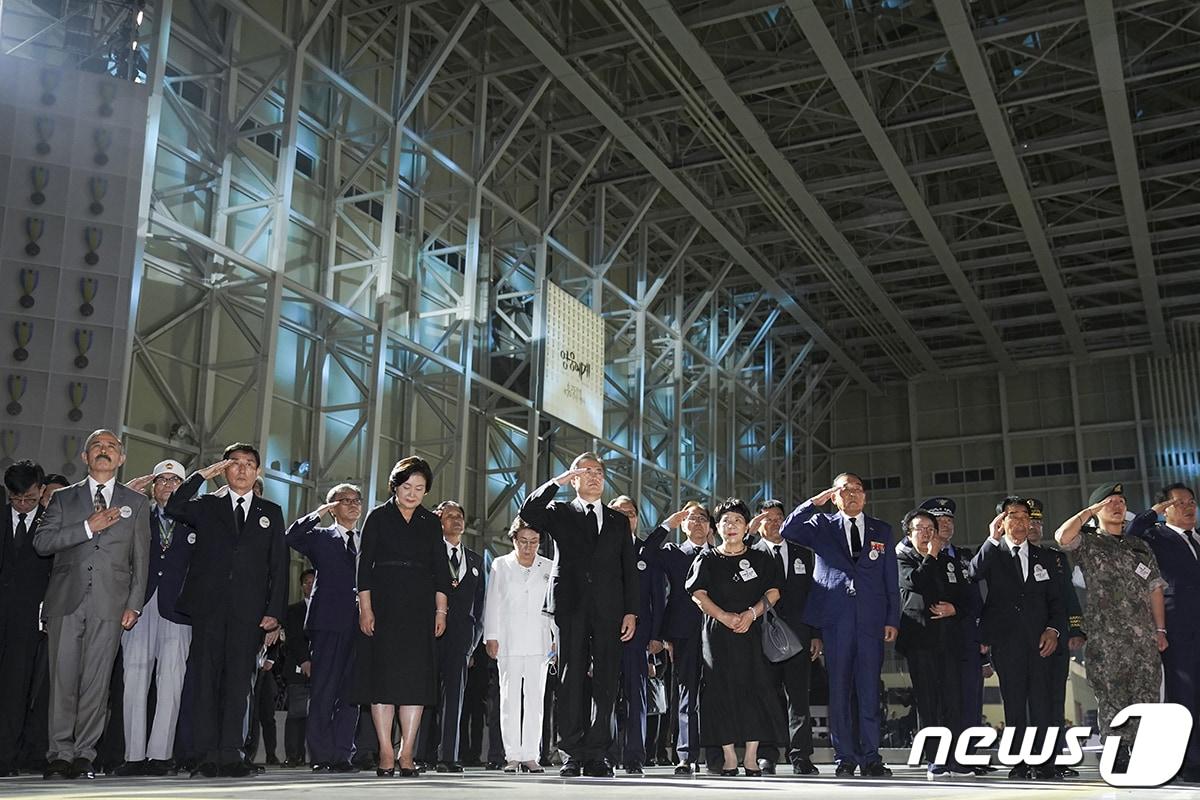 본문 이미지 - 문재인 대통령이 25일 경기 성남 서울공항에서 열린 6.25전쟁 70주년 행사에서 참석자들과 함께 봉송되는 국군전사자 유해를 향해 거수경례하고 있다.(청와대 제공)2020.6.26/뉴스1