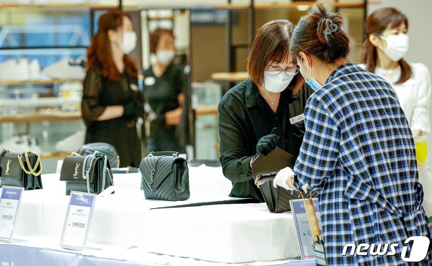26일 오전 서울 롯데백화점 영등포점에서 열린 면세 명품 대전에서 번호표를 받은 고객들이 제품을 둘러보고 있다. 롯데쇼핑은 이날부터 시작하는 '대한민국 동행세일'에 발맞춰 롯데백화점, 롯데아울렛 8개점에서 해외 명품을 최대 60% 할인하는 '면세 명품 대전'을 진행한다. 2020.6.26/뉴스1 ⓒ News1 안은나 기자