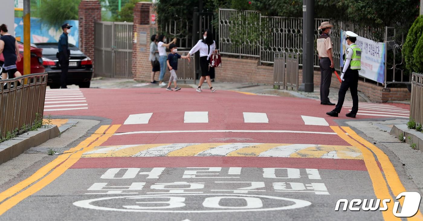 본문 이미지 - 어린이보호구역 내 불법 주·정차 주민신고제가 본격 시행된 지난달 29일 서울의 한 초등학교 앞 어린이보호구역에서 경찰들이 주·정차 단속과 어린이 교통안전 지도를 하고 있다./뉴스1ⓒ News1