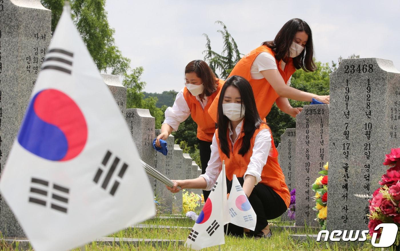 본문 이미지 - 현충일을 앞두고 3일 오전 대전 유성구 국립대전현충원 사병 3묘역에서 김신연 한화커뮤니케이션위원회 사장과 한화그룹 충청지역봉사단이 순국선열의 숭고한 정신을 기리며 묘비닦기, 태극기교체 작업 등 봉사활동을 하고 있다. 2020.6.3/뉴스1 ⓒ News1 김기태 기자