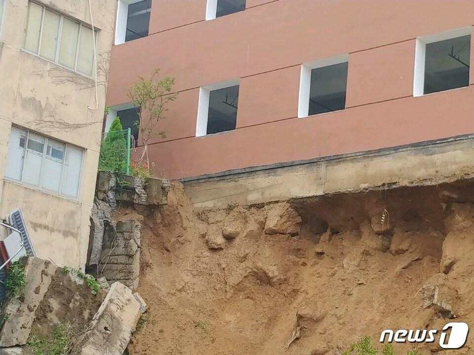 본문 이미지 - 30일 오전 8시10분쯤 부산 금정구 구서동의 한 아파트와 인근 신축공사장 사이에 있던 축대가 호우로 무너져 내렸다. 축대가 붕괴돼 흙과 모래가 쓸려내려온 모습.(부산지방경찰청 제공)ⓒ 뉴스1
