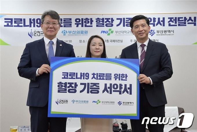 본문 이미지 - 8일 오후 부산시청에서 열린 '코로나19 치료를 위한 혈장 기증서약서 전달식'에서 변성완 부산시장 권한대행(왼쪽부터) 서약자 대표 김지선 씨, 노정각 온천교회 담임목사가 기념촬영을 하고 있다. 이날 온천교회 신도 중 완치 판정을 받은 21명이 기부에 동참했다. 2020.6.8 ⓒ 뉴스1