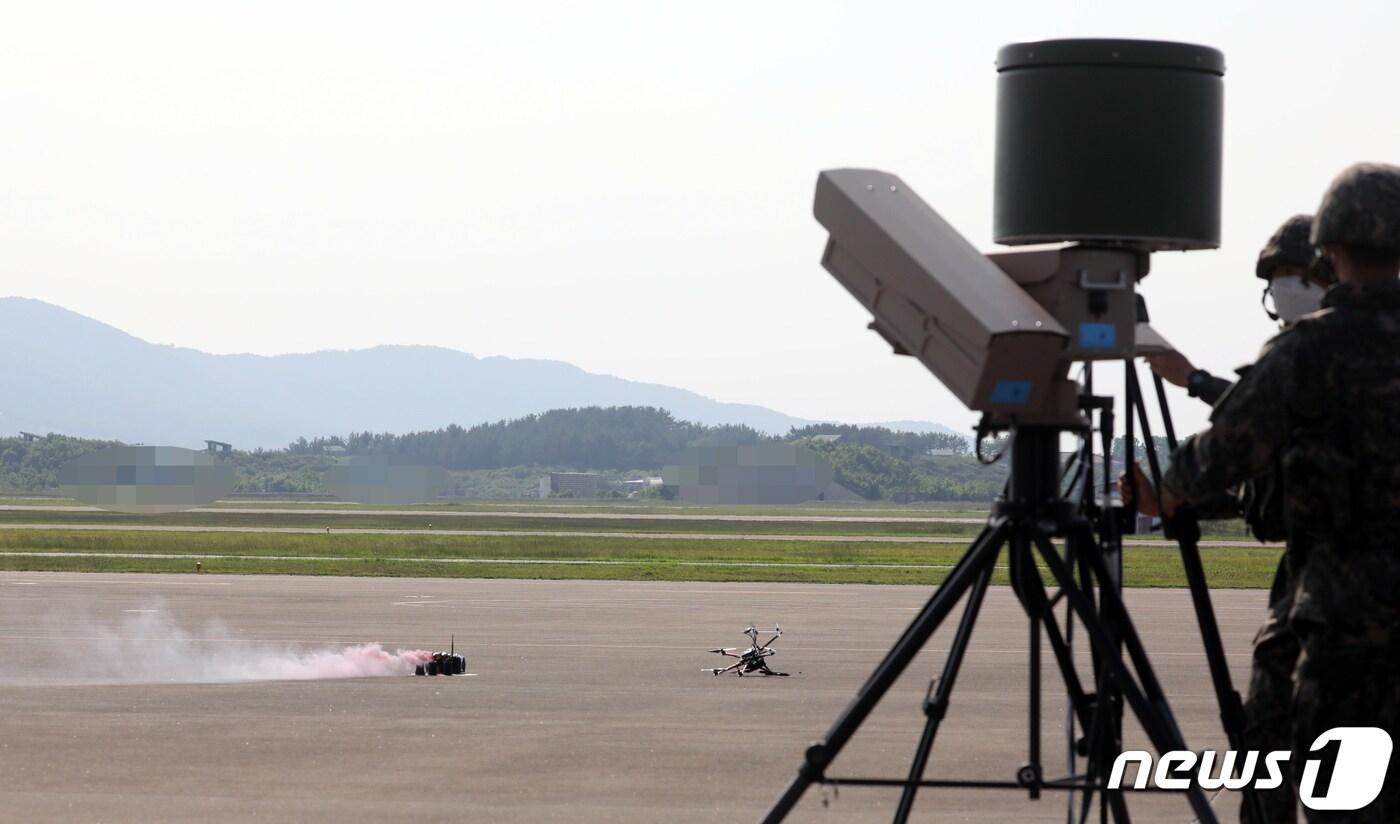 본문 이미지 - 2020년 6월 9일 충남 서산시 공군20전투비행단에서 열린 '지능형 스마트 부대' 구축체계 시연행사에서 재밍(Jamming)기술을 이용한 재머가 쏜 방해전파로 추락한 적 침투용 드론이 화생방 물질을 내뿜고 있다. ⓒ News1 장수영 기자