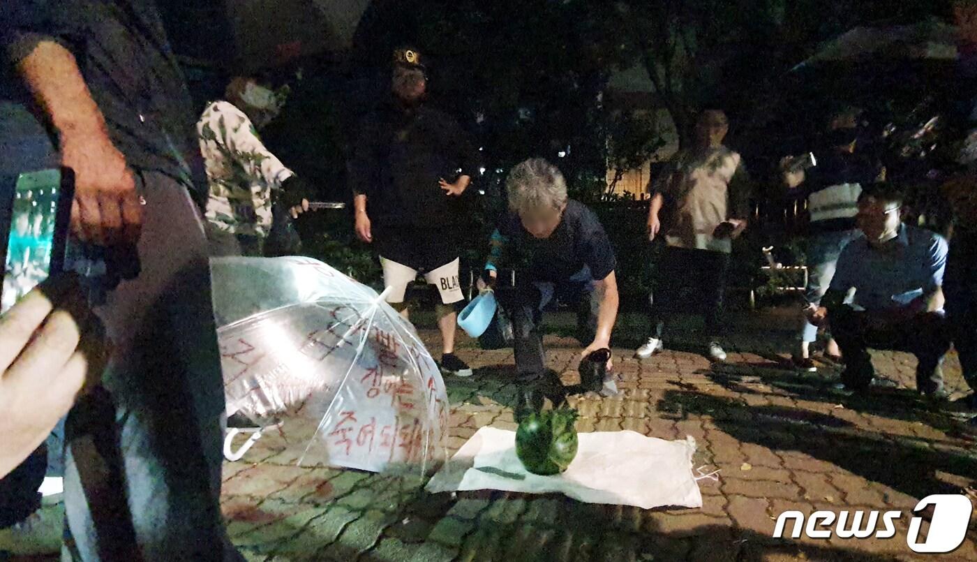 본문 이미지 - 문재인 대통령을 향해 신발을 벗어 던진 뮤지컬 극단 '긍정의 힘' 정창옥 단장(57)이 19일 오후 법원의 영장이 기각되면서 서울 영등포경찰서 유치장을 나와 신발로 수박을 깨는 퍼포먼스를 하고 있다. 서울 남부지법 김진철 영장전담 부장판사는 이날 오후 11시께 "증거를 인멸하거나 도망할 염려가 있다고 보기 어렵고, 구속의 상당성 및 필요성이 부족하다＂면서 구속영장을 기각했다. 2020.7.19/뉴스1 ⓒ News1 황덕현 기자