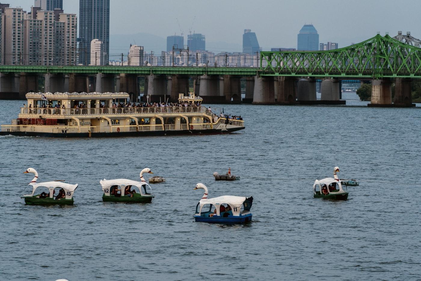 본문 이미지 - 해 질 녘 한강 파라다이스 건물 전망대에서 바라본 풍경. 한강유람선이 한강철교를 향해 가고 있다. 오리배는 한강 파라다이스 건물에서 탈 수 있다. 이하 서울관광재단 제공