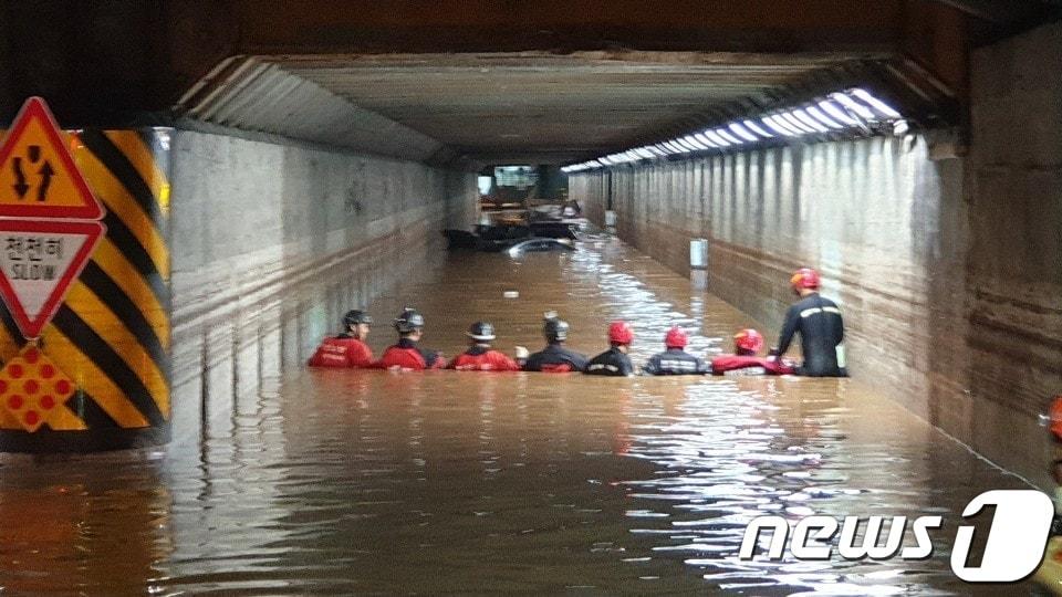본문 이미지 - 23일 밤부터 부산에 최대 200mm가 넘는 폭우가 쏟아지면서 부산역 인근 초량 제1지하차도가 물에 잠겼다. 이로 인해 차량 안에 있던 3명이 구조됐으나 숨졌다. 사진은 119 구조대원들이 지하차도 배수작업과 구조작업에 들어간 모습.(부산경찰청 제공).2020.7.24/뉴스1 ⓒ News1 박세진 기자