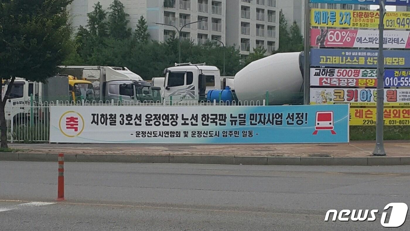 본문 이미지 - 운정신도시 도로변에 걸린 3호선 운정연장 사업의 한국판 뉴딜사업 반영을 환영하는 현수막.(운정연 제공) ⓒ 뉴스1