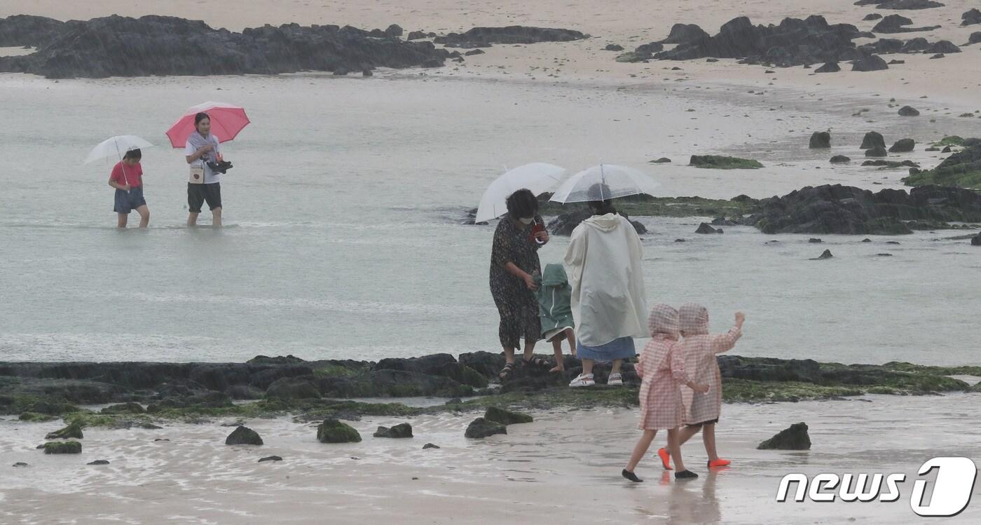 비가 내리는 7일 오후 제주시 금능해수욕장에서 관광객들이 해변을 거닐고 있다.2020.7.7/뉴스1 ⓒ News1 오현지 기자