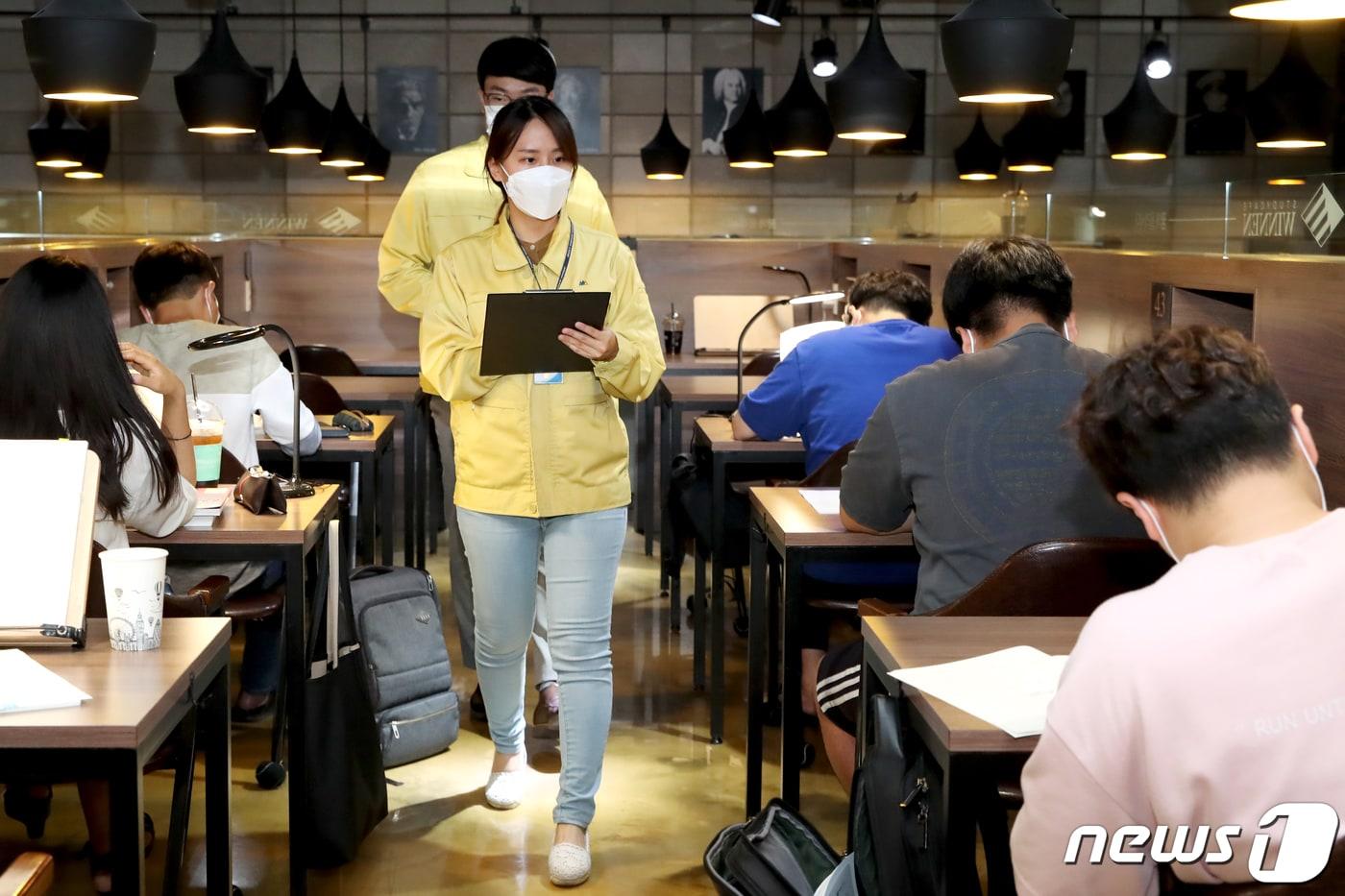 서울 성동구청 직원들이 8일 오전 관내 스터디카페 이용자들의 마스크 착용 여부와 거리두기를 점검하고 있다. (성동구청 제공) 2020.7.8/뉴스1