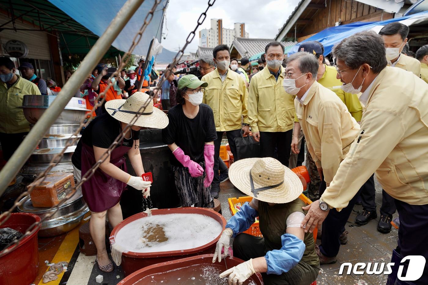 문재인 대통령이 12일 집중호우 피해를 입은 전남 구례군 구례5일장을 찾아 상인들을 격려하고 있다. 지난 6일 경기 연천군 군남댐 방문에 이어 문 대통령이 집중호우 관련 현장을 찾은 것은 이번이 두 번째다. (청와대 제공) 2020.8.12/뉴스1