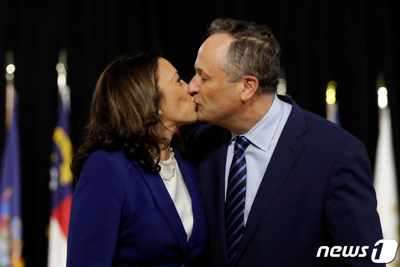 카멀라 해리스 미국 민주당 부통령 후보(왼쪽)가 지난 12일(현지시간) 델라웨어주 윌밍텅에서 진행된 조 바이든 대통령후보와의 합동 유세 도중 남편인 더글러스 엠호프와 입맞춤을 나누고 있다. ⓒ 로이터=뉴스1