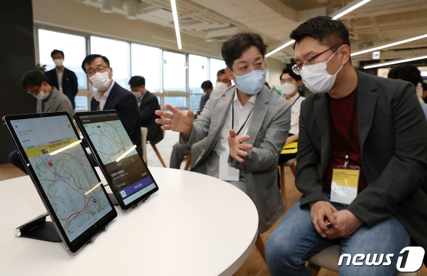 장석영 과학기술정보통신부 차관(왼쪽)과 류긍선 카카오모빌리티 대표가 14일 오전 경기 성남 판교의 카카오모빌리티 본사에서 카카오T 앱미터기 서비스 시연을 살펴보고 있다. 2020.8.14/뉴스1 ⓒ News1 박세연 기자