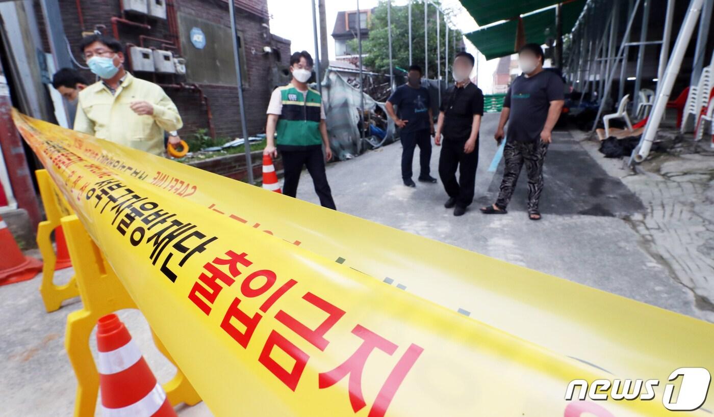 성북구 직원들이 14일 서울 성북구 장위동 사랑제일교회에서 신종 코로나바이러스 감염증(코로나19) 집단발병으로 통제선을 설치하자 남앙 있는 교인들이 지켜보고 있다. 사랑제일교회에서 단 이틀만에 13명이 코로나19 확진되는 등 급속히 퍼져나가고 있어 방역당국이 시설폐쇄조치를 내렸다. 2020.8.14/뉴스1 ⓒ News1 김명섭 기자