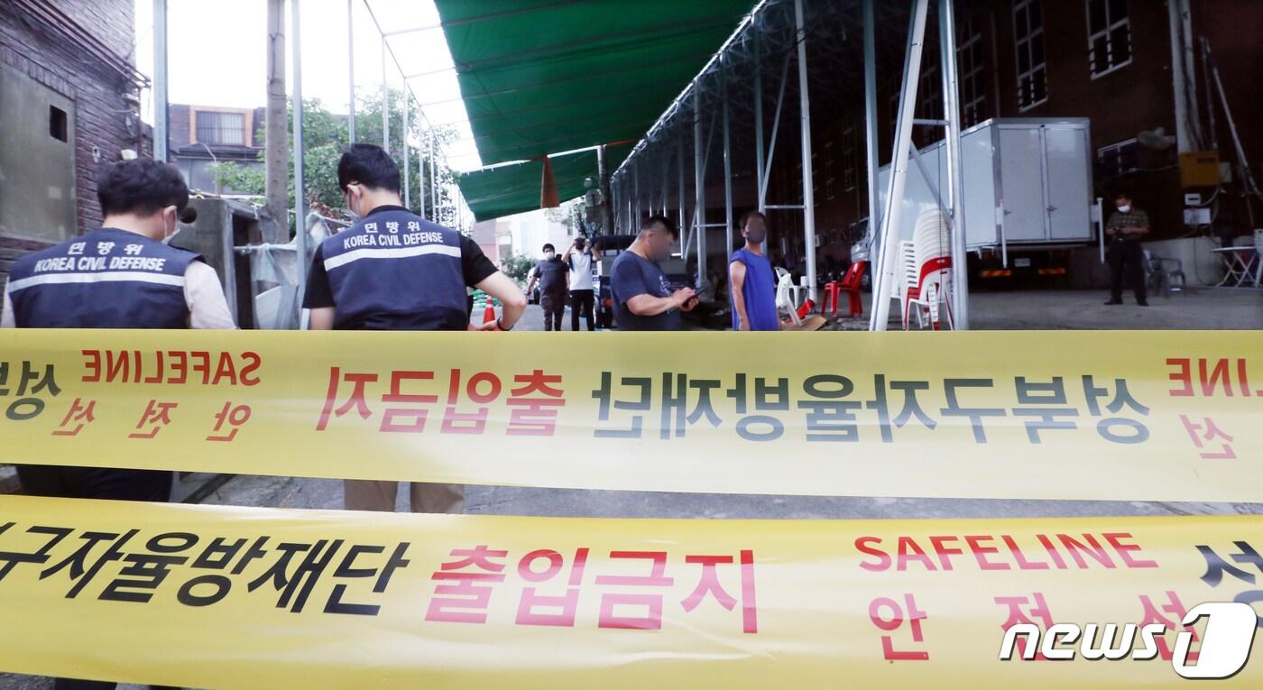 성북구 직원들이 14일 서울 성북구 장위동 사랑제일교회에서 신종 코로나바이러스 감염증(코로나19) 집단발병으로 통제선을 설치하자 남앙 있는 교인들이 지켜보고 있다. 사랑제일교회에서 단 이틀만에 13명이 코로나19 확진되는 등 급속히 퍼져나가고 있어 방역당국이 시설폐쇄조치를 내렸다. 2020.8.14 ⓒ News1 김명섭 기자