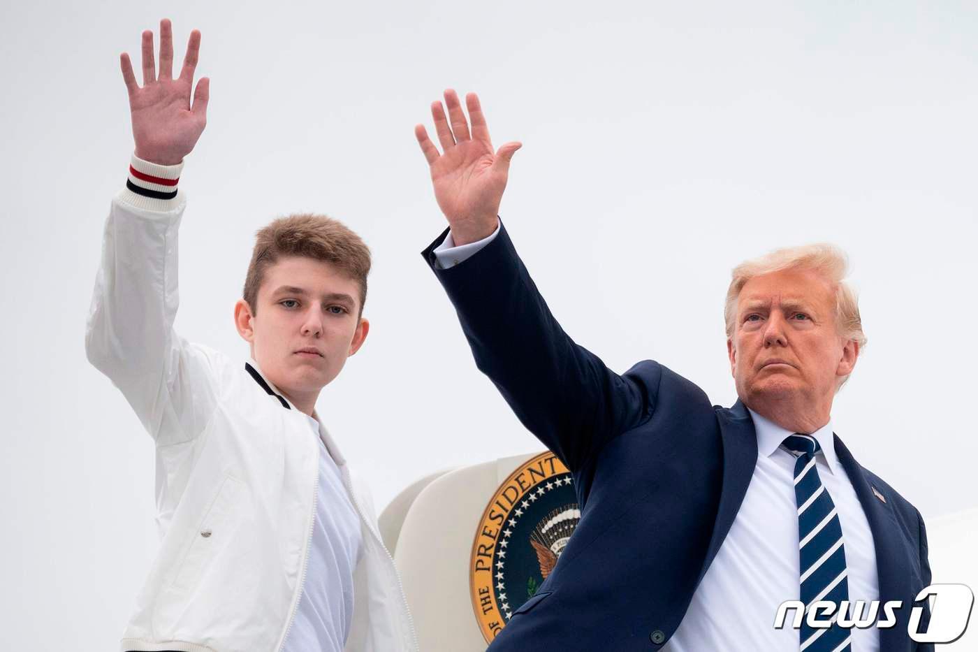 도널드 트럼프 미국 대통령과 아들 배런이 16일 (현지시간) 뉴저지주 모리스타운 공항에서 전용기를 타면서 손을 흔들고 있다. ⓒ AFP=뉴스1 ⓒ News1 우동명 기자