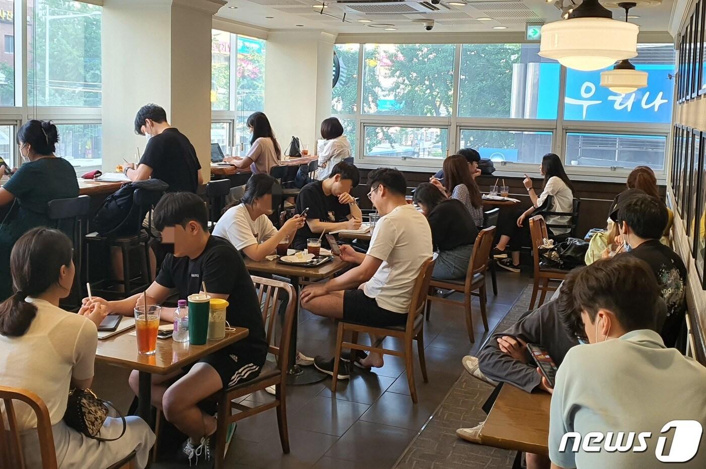 18일 오후 부산의 한 커피 전문점에는 '사회적 거리두기 2단계' 시행에도 불구하고 마스크를 착용하지 않은 채 다닥다닥 붙어있는 시민들로 가득찼다.2020.8.18 /뉴스1ⓒ 노경민 기자