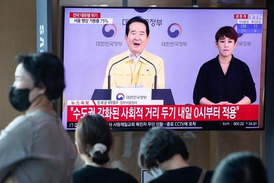 본문 이미지 - 18일 서울역에서 시민들이 신종 코로나바이러스 감염증(코로나19) 사태와 관련한 정세균 국무총리의 대국민담화를 지켜보고 있다. 정 총리는 지난 16일 서울과 경기지역을 대상으로 실시한 사회적 거리두기 2단계 격상을 보다 강화하기 위해 해당 지역에 인천을 추가하기로 했다고 대국민담화를 통해 밝혔다. 2020.8.18/뉴스1 ⓒ News1 유승관 기자