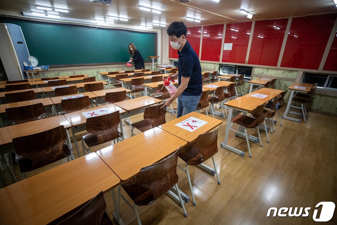 본문 이미지 - 19일 서울 양천구 목동의 한 학원에서 관계자들이 방역 작업을 하고 있다. ⓒ News1 유승관 기자
