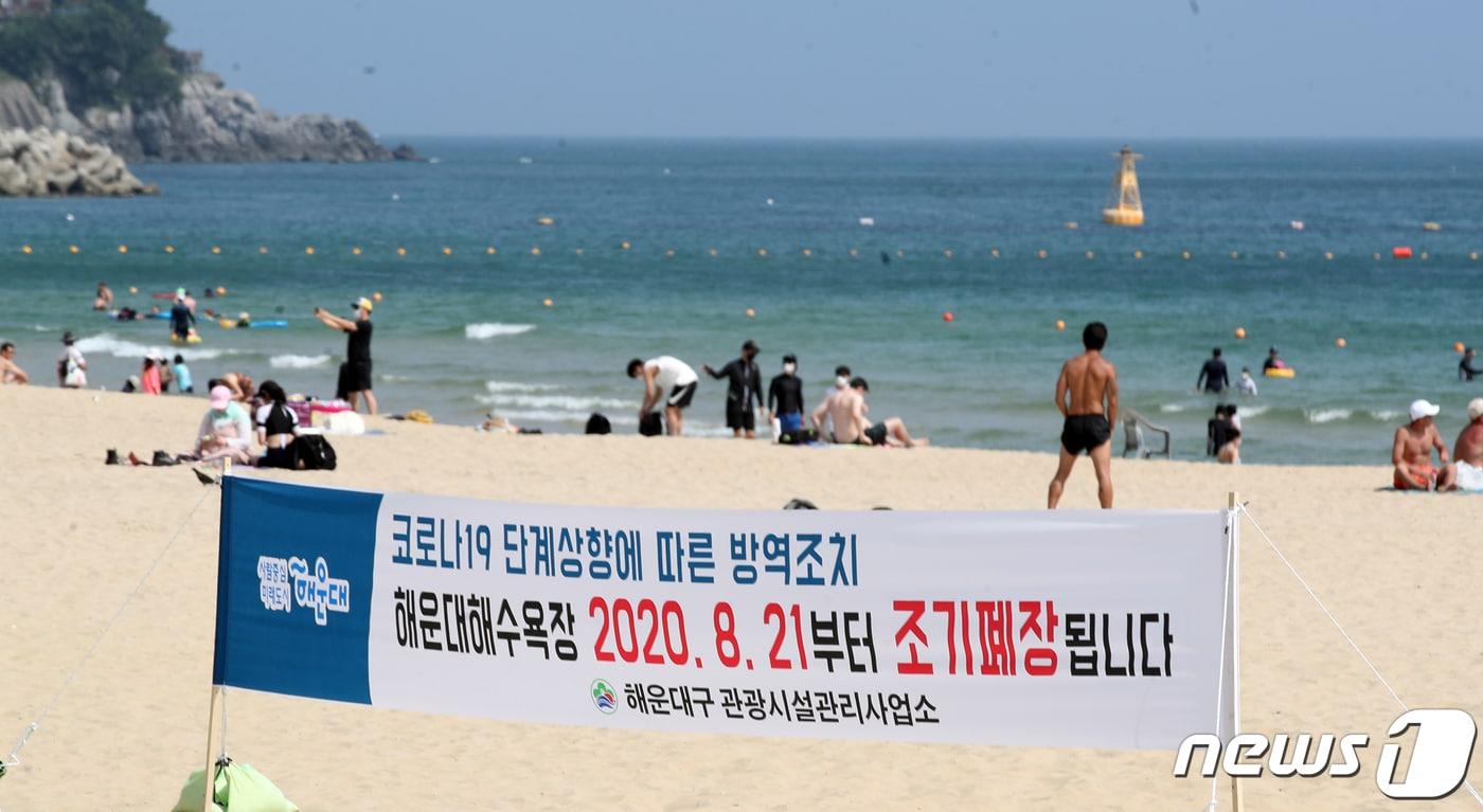 본문 이미지 - 신종코로나 바이러스 감염증(코로나19) 확진자가 연일 발생하고 있는 21일 부산 해운대해수욕장에 조기 폐장 현수막이 걸려있다. 오는 31일까지 운영 예정이었던 해운대 등 7개 해수욕장은 21일 0시부터 조기 폐장에 들어갔다. 2020.8.20/뉴스1 ⓒ News1 여주연 기자