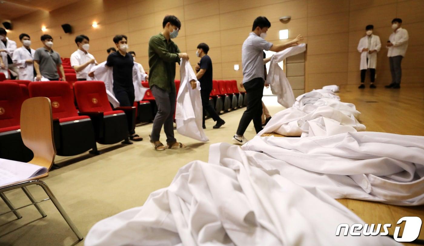 본문 이미지 - 정부의 의과대학 정원 확대 등에 반대하는 전공의들이 23일 오전 한 병원에서 의사 가운을 벗는 퍼포먼스를 벌이고 있다. 2020.8.23/뉴스1 ⓒ News1 박지혜 기자