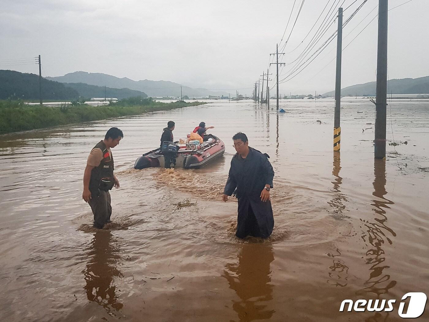 본문 이미지 - 지난 5일 철원 한탄강이 폭우로 범람하면서 인근의 동송읍 이길리와 갈말읍 정연리 마을 전체가 순식간에 물바다로 변했다. 사진은 철원군 직원들이 마을 내 고지대에 남아 있는 주민들에게 건네줄 생필품을 보트에 싣고 출발하는 모습. 2020.8.5/뉴스1 ⓒ News1 김정호 기자