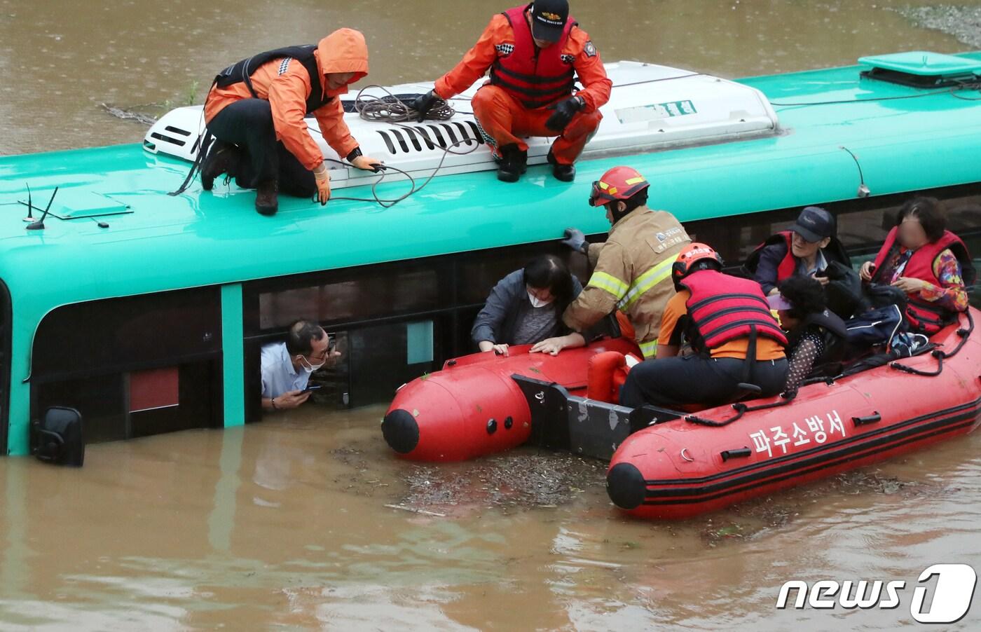 본문 이미지 - 파주소방서 구조대가 6일 오전 임진강 인근인 경기도 파주시 파평면 율곡1리에서 침수된 시내버스에서 고립된 승객과 운전사 5명을 구조하고 있다. 2020.8.6/뉴스1 ⓒ News1 김명섭 기자