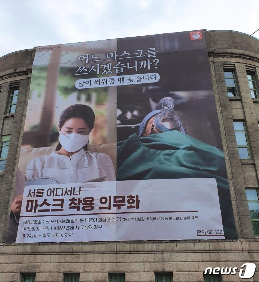 본문 이미지 - 서울도서관 벽면에 붙어있는 대형 통천의 모습. '어느 마스크를 쓰시겠습니까?'라고 묻고 있다.(서울시 제공)/뉴스1ⓒ News1