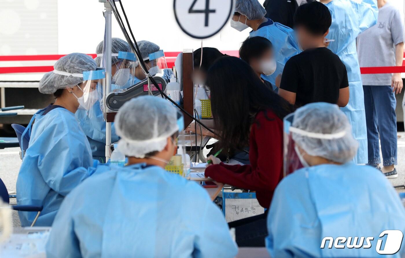 본문 이미지 - 15일 오전 서울 강남구 보건소에 마련된 선별진료소에서 의료진이 학부모와 아이들의 문진표를 확인하고 있다./뉴스1 ⓒ News1 이동해 기자
