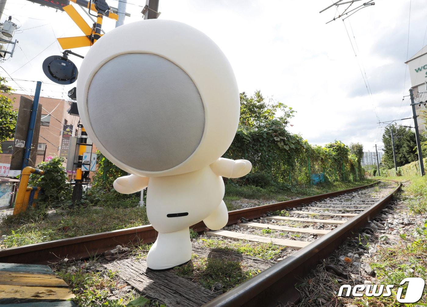 본문 이미지 - 2002년 자취를 감춘 LG텔레콤(현 LG유플러스) 마스코트 '홀맨'이 18년만에 돌아왔다. 귀여운 생김새와 어딘지 모르게 어설픈 모습의 '홀맨'은 당시 한국문화콘텐츠진흥원 지정 '캐릭터 베스트 10'에 선정되는 등 2000년대 초 10대를 중심으로 큰 인기를 끌었지만 피처폰 시대가 저물면서 자취를 감췄다. 24일 서울의 한 기찻길에서 새롭게 돌아온 '홀맨'이 카메라를 향해 포즈를 취하고 있다. 2020.9.24/뉴스1 ⓒ News1 이성철 기자
