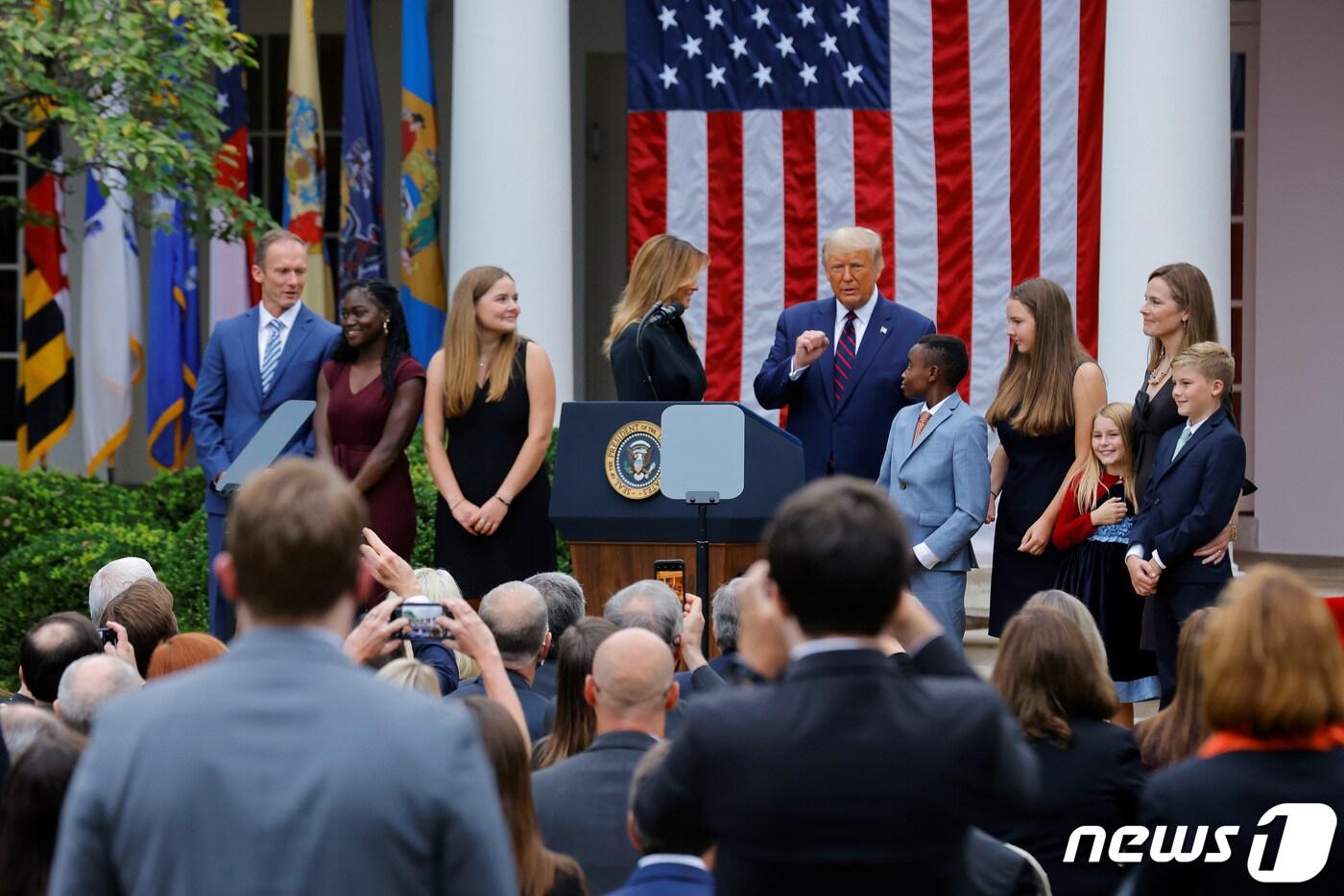 도널드 트럼프 미국 대통령이 에이미 코니 배럿을 연방대법관 후보로 지명하는 자리에 배럿의 가족들이 모두 참가했다. 맨 왼쪽이 남편이며, 맨 오른쪽 아이의 허리를 안고 있는 사람이 배럿이다.  두 명의 흑인도 보인다. ⓒ 로이터=뉴스1 ⓒ News1 