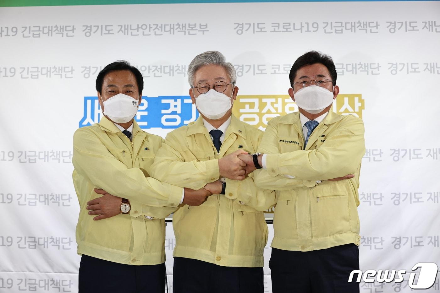 이재명 경기도지사(가운데)가 9일 경기도청에서 코로나19 극복을 위한 경제정책 발표 기자회견 후 장현국 경기도의회 의장(왼쪽), 박근철 경기도의원과 손을 맞잡고 있다. 이날 이 지사는 “코로나19로 인한 소상공인 등 극단적 위기상황에 빠진 골목경제를 살기기 위해 추석 경기 살리기 한정판 지역화폐를 지급한다”고 밝혔다. 2020.9.9/뉴스1 ⓒ News1 경기사진공동취재단