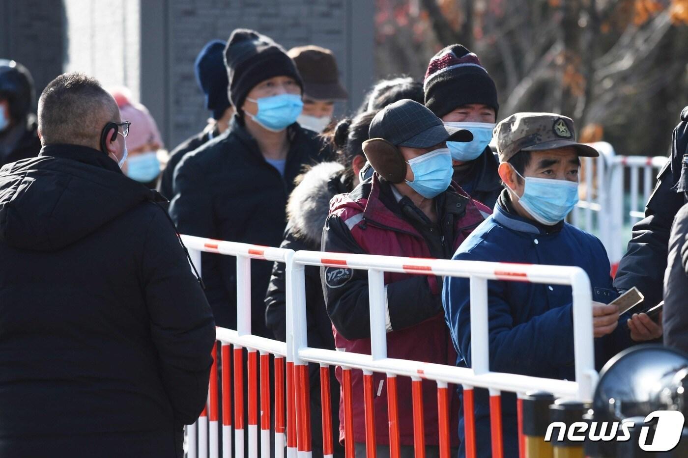 12일 중국 수도 베이징에서 노동자들이 코로나19 백신을 맞기 위해 줄을 서 있다. ⓒ AFP=뉴스1